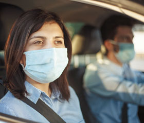Dos personas con mascarilla en el interior de un coche