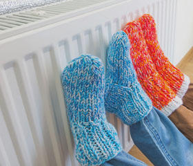 Pies con calcetines de lana apoyados en un radiador.