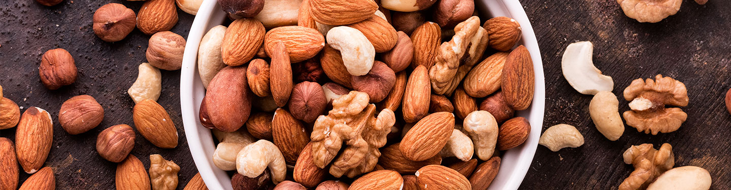 Frutos secos en un bowl y extendidos por una mesa