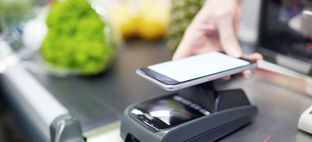 Persona pagando con el móvil sobre un datafono