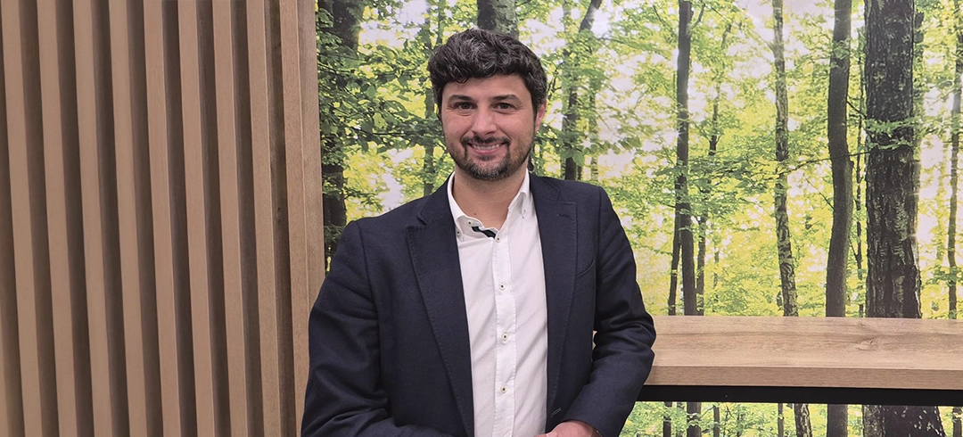 Aurelio posando para la fotografía con un bosque de fondo
